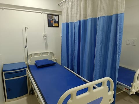 Private patient recovery room with bed and curtain at Osteon Orthopedic Hospital, Pimple Saudagar