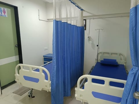 In-patient ward with hospital beds and curtain partitions at Osteon Orthopedic Hospital, Pimple Saudagar