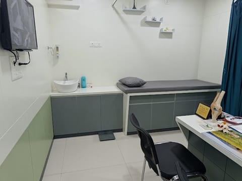 Examination room with patient bed and orthopedic models at Osteon Orthopedic Hospital, Pimple Saudagar