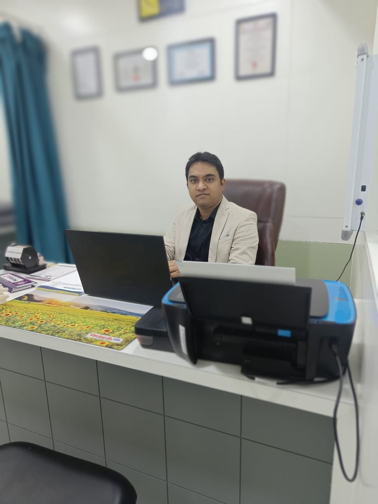Dr. Harshal V Kalambe Patil seated at consultation desk with certificates on wall, Osteon Orthopedic Hospital